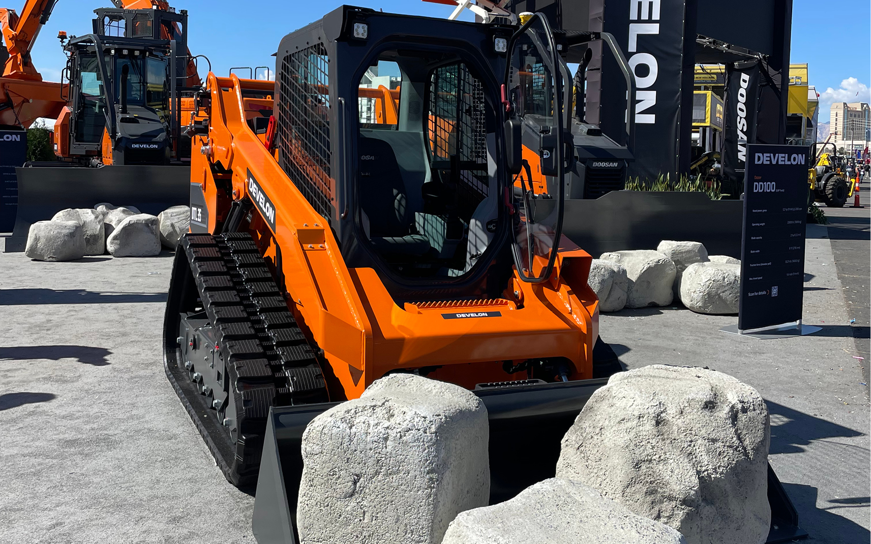 Alt Text: A picture of a DEVELON compact track loader with a bucket attachment on display at CONEXPO-CON/AGG.